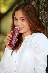 Jolie jeune femme mangeant un smoothie