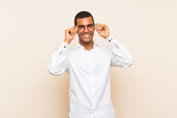 Young handsome brunette man over isolated background with glasses and surprised