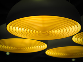 Selective focus of geometric circular ceiling lights in the dark. Abstract background.