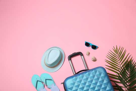 Flat lay composition with suitcase and space for text on pink background