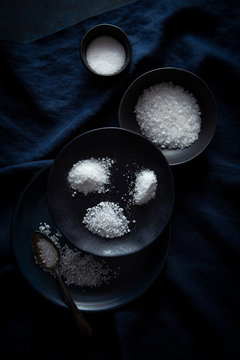 various salts on dark blue plates and linen
