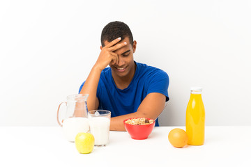 Young man having breakfast in a table laughing