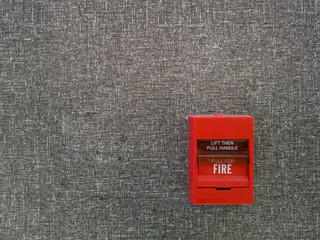 Fire alarm switch on carpet grey wall, Lift then pull handle to alarm, safty system concept, Copyspace and background.