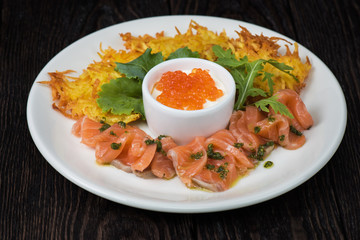 Plate with potato pancakes salmon fish and red caviar