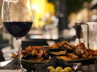 glass of wine with dinner food and olives