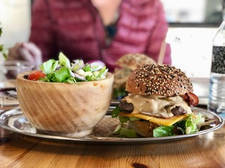 hamburger and salad with person in background