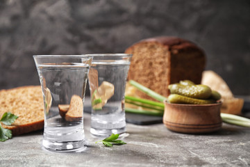 Cold Russian vodka with snacks on grey table, closeup