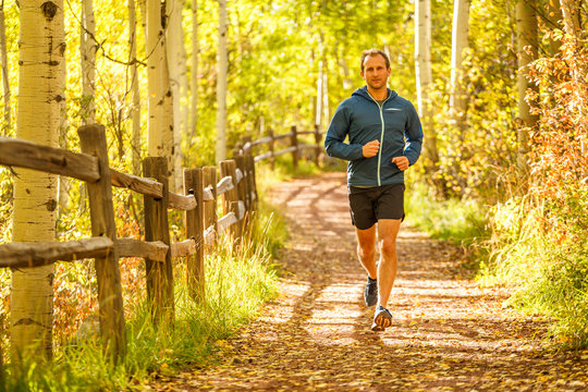 Telluride, Colorado, USA: A male runner jogging along a trail on a sunny autumn day.