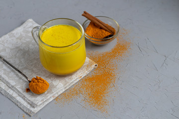 Golden milk with spices. Turmeric, cloves, black pepper and a drop of vegetable oil. Traditional indian drink. On a light background. Healthy eating Copy space. 
