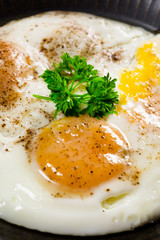Fried eggs and bread for breakfast on a gray background.