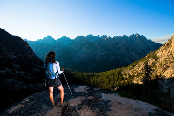 A woman enjoys the dramatic view of a of the Sawtooth Mountains near the Elephant's Perch, a popular climbing destination by the beautiful Saddleback Lakes. The whole area is so stunning it has earned the nickname 'Shangrila.