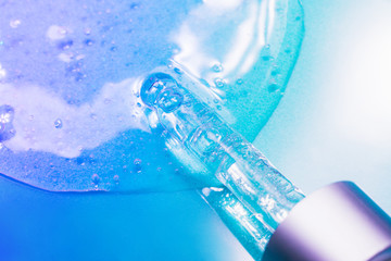 Face serum close-up on the trendy neon background. Collagen, hyaluronic acid for skin care. Achievements of modern science in cosmetic to preserve beauty. Close-up.