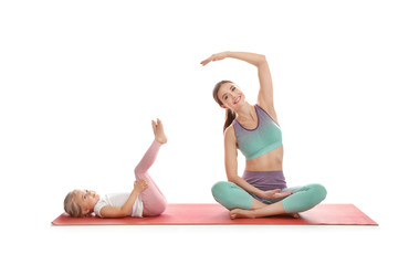 Young woman and her daughter doing exercise isolated on white. Home fitness