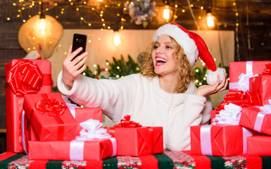 Obraz na płótnie Canvas Capturing a happy moment. christmas blogging. making selfie. happy woman hold phone. xmas morning. party celebration. woman santa hat. happy new year. selfie time. video call to family