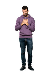Full-length shot of Handsome man with sweatshirt having a pain in the heart over isolated white background