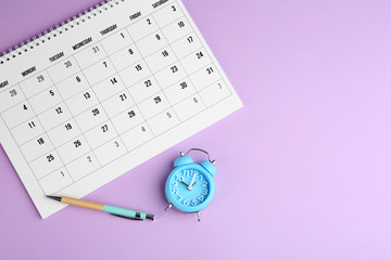Calendar, pen and alarm clock on violet background, flat lay