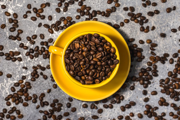 cup of coffee with beans on gray stone background