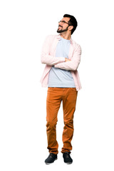 Fototapeta premium Full-length shot of Handsome man with beard looking up while smiling over isolated white background