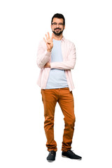 Naklejka premium Full-length shot of Handsome man with beard happy and counting four with fingers over isolated white background