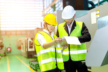 Businessmen or male engineers and female engineers are working in industrial plants that have machines and injection molds