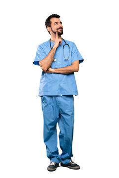 Full-length shot of Surgeon doctor man thinking an idea while looking up over isolated white background