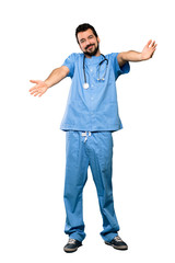 Fototapeta premium Full-length shot of Surgeon doctor man presenting and inviting to come with hand over isolated white background