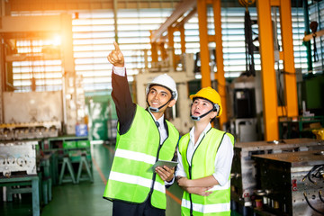 Businessman or engineers are training new employees In industrial plants that have machines and injection molds. The concept of welcoming new employees, teaching, training