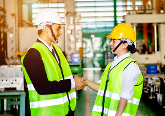 Businessmen or male engineers and female engineers are working in industrial plants that have machines and injection molds