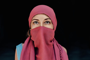 Beautiful Arabic woman in red hijab with bright makeup on black colored background. Cappadocia. Turkey