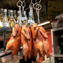 Naklejka premium Whole grilled chicken hanging at restaurant