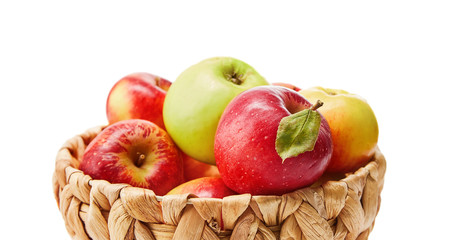Red apples in wicker basket. Fruity still life. Isolated on white background.