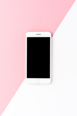 White smartphone with empty screen on abstract background. Top view