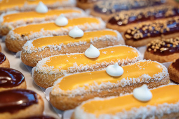 Assorted colorful eclair displayed in glass showcase box