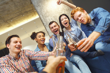 Group of friends having party indoors fun together cheers with photographer