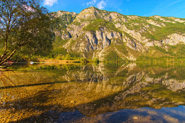 Wide angle landscape view Bohinj Lake with mountain range which reflected in turquoise water. ...