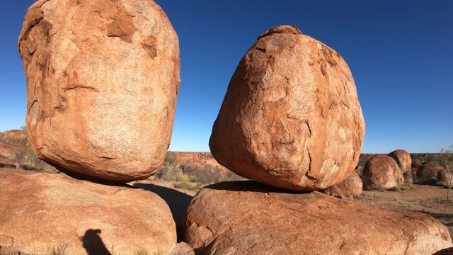 Australia, Northern Territory. Aboriginal land in Red Centre. Sunbeams sky with the Eggs of mythical Rainbow Serpent at Karlu Karlu - Devils Marbles Conservation Reserve in the morning.