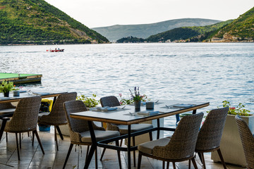 Sunny view of coastal cafe with beautiful view of Kotor Bay, Perast, Montenegro.