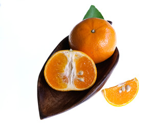 Orange fruits and halves, sliced ​​on a wooden plate, isolated on a white background.