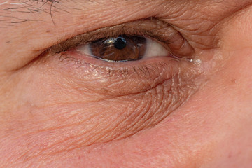 Closeup of man eye with a tear drop.