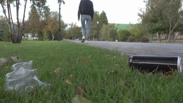 girl throws used aluminum barrel on the lawn, litter the environment