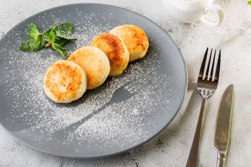 Cottage cheese pancakes, Syrniki or Cheesecakes with cream, honey, mint isolated on white marble background. Homemade food. Tasty breakfast. Selective focus. Hotizontal photo.