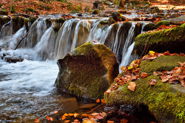 Beautiful landscape with a waterfall in the autumn forest