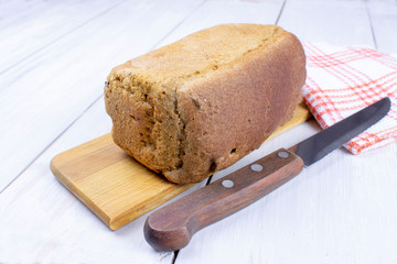 Rye bread on a cutting board and a knife