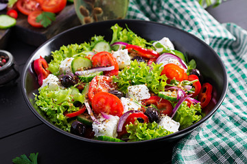 Healthy food. Greek salad with cucumber, tomato, sweet pepper, lettuce, red onion, feta cheese and olives.