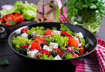 Healthy food. Greek salad with cucumber, tomato, sweet pepper, lettuce, red onion, feta cheese and olives.