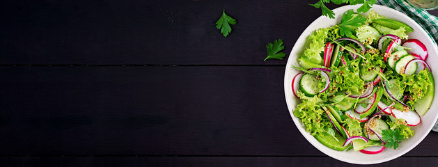 Healthy vegan food. Vegetarian vegetable salad of radish, cucumbers, lettuce  and red onion.  Top...