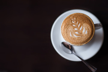 A Cup of hot latte art coffee on wooden table coffee