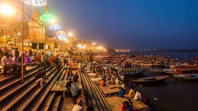 People watching hindu priests performing Agni Puja or Worship of Fire at a ghat in Varanasi day to night time lapse