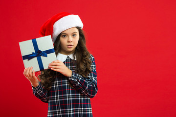 Lets open and look inside. Christmas shopping. Little girl child in santa red hat. Present for Xmas. Childhood. New year party. Santa claus kid. Happy winter holidays. Small girl