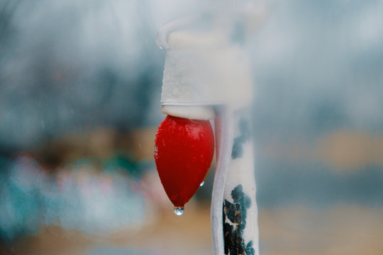 Red Christmas Light Bulb In Fog And Rain, Wet Holiday Season Concept With Copy Space.